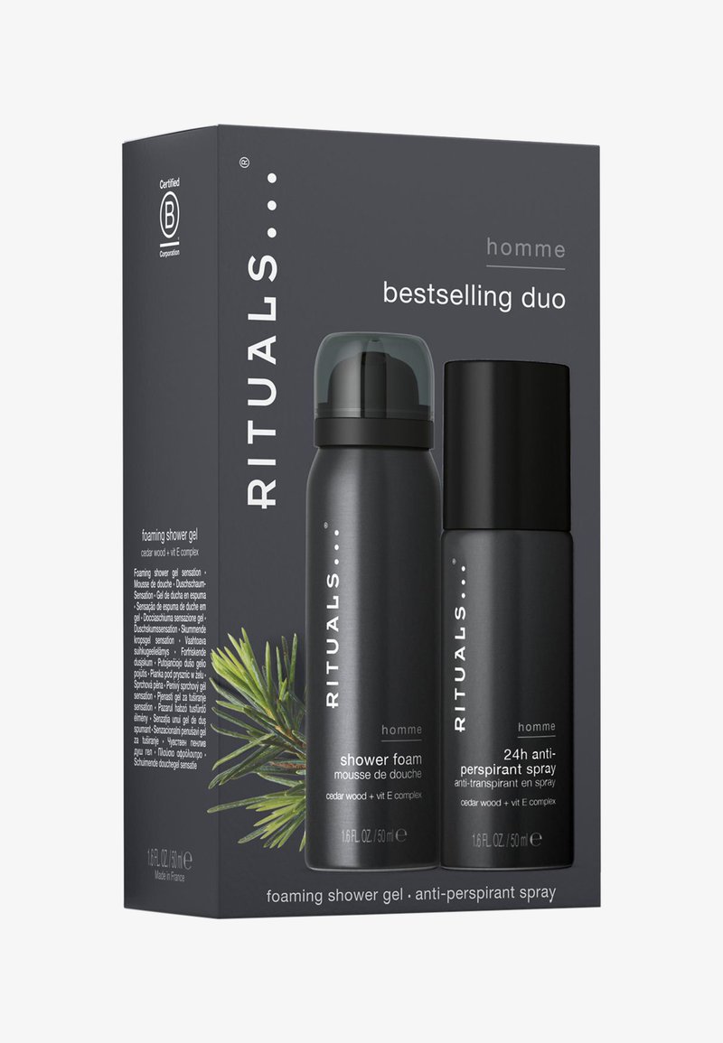 Svart rektangulær eske som inneholder to produkter: et dusjskum og en antiperspirantspray, begge i elegante svarte beholdere.