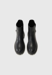 Sorte lær ankle boots med en glat tekstur, elastiske sidestykker og slidstærke gummisåler. Har en rund tå og minimal dekoration.