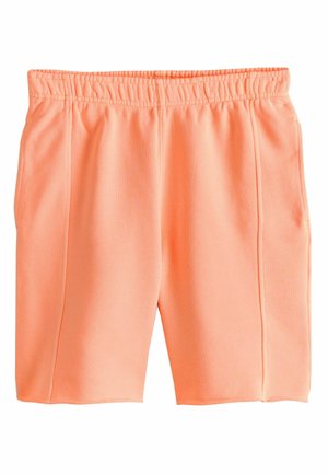Jasnopomarańczowe krótkie spodenki z elastyczną talią, bocznymi kieszeniami oraz widocznymi pionowymi szwami na białym tle.