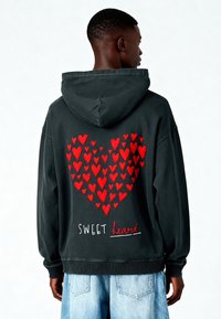 Felpa con cappuccio grigio scuro con un grande design a forma di cuore rosso composto da cuori più piccoli e con la scritta ricamata "SWEET heart" in basso.