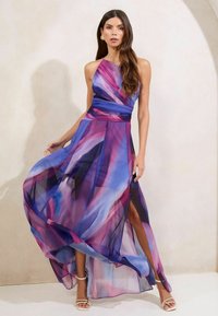 Flowing, sleeveless dress in sheer fabric featuring purple and pink abstract patterns, side slit, and a gathered waist design.