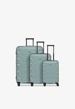 Tre valigie rigide color verde acqua di diverse dimensioni con manici telescopici neri e quattro ruote girevoli, disposte da sinistra a destra in ordine di grandezza.