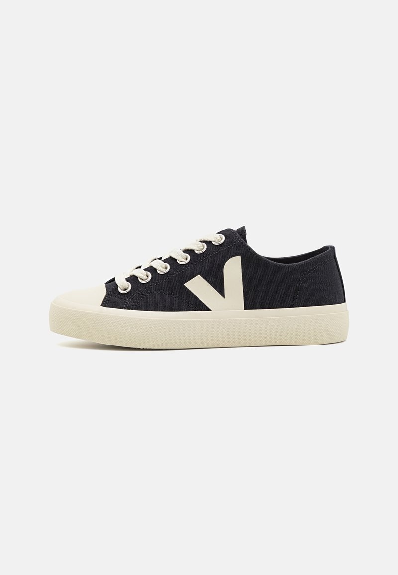 Navy canvas sneakers with cream laces and sole, featuring a large light-colored "V" logo on the side. Round toe and textured rubber sole.