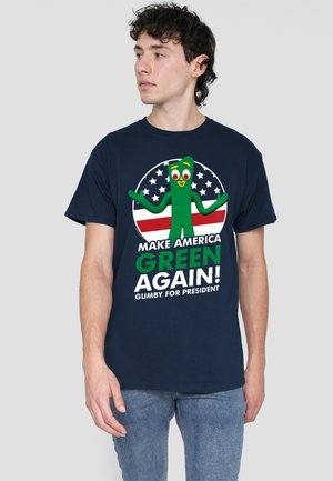 Navy cotton t-shirt featuring a green Gumby character with text “MAKE AMERICA GREEN AGAIN! GUMBY FOR PRESIDENT” against a circular backdrop.