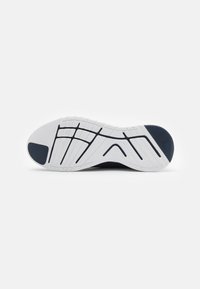 Shoe sole with white rubber traction pattern, featuring a navy blue accent. Textured surface for grip and stability. Distinctive design lines.