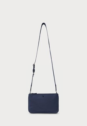 Sac en bandoulière bleu marine en matériau lisse, de forme rectangulaire slim avec une longue sangle réglable. Détail logo subtil à l'avant.