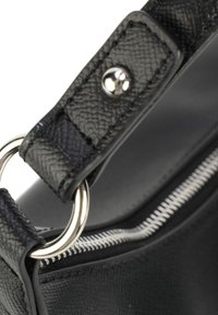 Manico di borsa in pelle nera testurizzata con hardware argentato, caratterizzato da un bottone a scatto e un dettaglio con zip lungo il bordo.