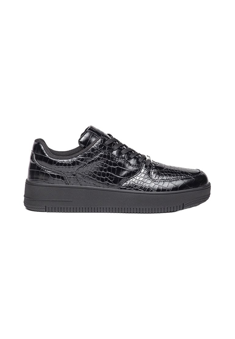 Zapatillas sintéticas negras con un brillo de patrón de cocodrilo, diseño de cordones y una gruesa suela de goma negra. Textura suave y forma redondeada.