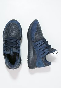 Scarpe da ginnastica blu navy con materiali in mesh e pelle scamosciata, punta rotonda, colletto imbottito, suola flessibile e dettagli frontali con lacci.