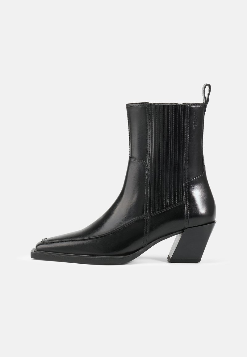 Black leather ankle boot with a pointed toe, ribbed side panels, and a block heel featuring a metallic accent. Smooth texture and sleek design.