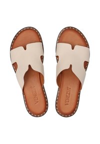 Beige leather slide sandals with a cut-out design, brown leather insole, and gold studs along the edges. Flat, open-toe style.