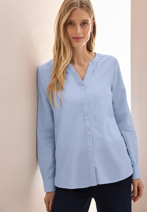 Helles blaues Langarmshirt mit V-Ausschnitt und Knopfleiste. Hergestellt aus weichem Stoff, mit lässigem Schnitt und subtiler Textur.