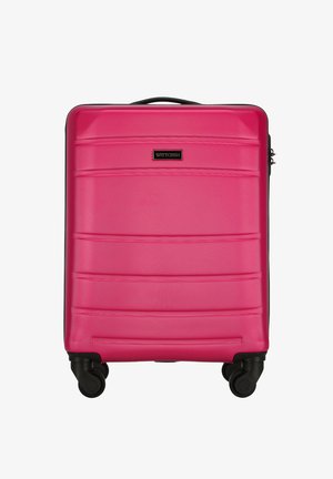 Różowa walizka kabinowa z twardą skorupą, wyposażona w cztery czarne obrotowe kółka oraz czarny górny uchwyt, z małym prostokątnym logo marki.