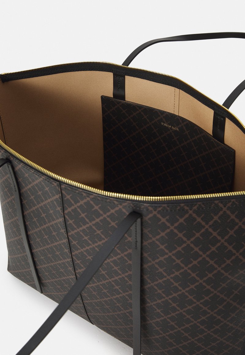 Grande borsa tote nera con esterno a motivo geometrico, cerniera dorata e interno beige. Dotata di due manici neri e una tasca a soffietto.