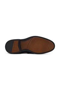 Sole di una scarpa formale nera con sezioni in pelle marrone e gomma nera per la presa nelle aree del tallone e delle dita, mostrata su uno sfondo bianco.