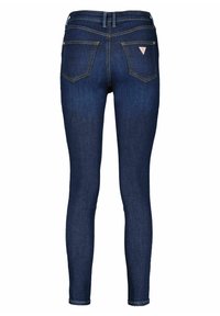 Úzké džíny z tmavě modrého denimu. Mají středně vysoký pas, dvě zadní kapsy s trojúhelníkovým logem a hladkou, lehce strukturovanou látku.