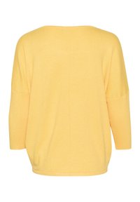 Gul oversized tröja med vid halsringning, trekvartslånga ärmar och ribbad textur. Har en enkel baksida med en mittsöm.