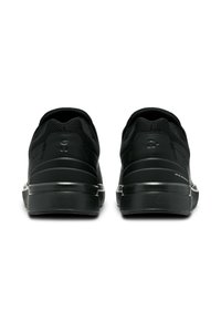 Schwarze Sportsneaker aus Mesh und synthetischen Materialien, mit niedrigem Profil, ausgestattet mit einer strukturierten Sohle und minimalem Branding an der Ferse.