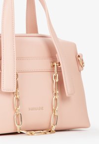 Borsa a mano in pelle rosa chiaro con un design strutturato, caratterizzata da un accento in catena dorata, logo impresso e manici doppi.
