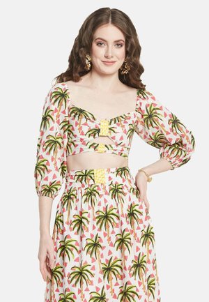 Conjunto de dos piezas que incluye un top corto y una falda, con fondo blanco decorado con estampados coloridos de palmeras y sandías, mangas abullonadas y acentos en amarillo.