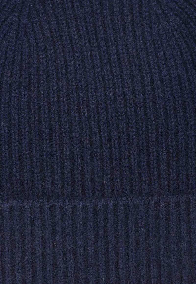 Marineblaue Strickmütze mit geripptem Muster, die enge und lockere Strukturen aufweist. Hergestellt aus weichem, warmem Stoff mit einem umgeschlagenen Saum.