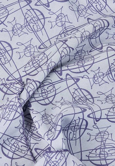 Μπλε ύφασμα με αφηρημένο σχέδιο διασυνδεδεμένων κυκλικών και γραμμικών σχημάτων σε σκούρο μπλε, εμφανιζόμενο με πτυχές και ορατή ραφή.