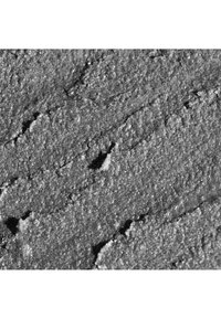 Tekstureret overflade af gråt sand med spredte granulater, der viser varierede mønstre og et ru, ujævnt udseende.