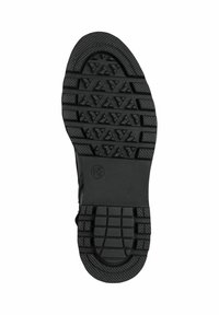 Semelle en caoutchouc noir avec un profil texturé comportant des motifs triangulaires et rectangulaires, conception légère et talon arrondi.