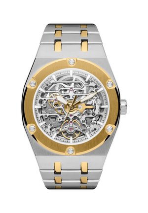 Silver and gold skeleton wristwatch with visible mechanical gears, gold bezel with screws, and a silver and gold metal link bracelet.