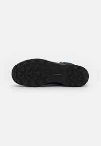 Schwarze Wanderschuhsohle mit tiefen Traktionsstollen, versehen mit "LOWA"-Logo. Texturiertes Gummi für Langlebigkeit und Stabilität auf verschiedenen Untergründen.