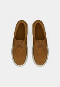 Καφέ δερμάτινα παπούτσια με ομαλή υφή, με στρογγυλή μύτη, σχέδιο με κορδόνια και αντιθετική λευκή σόλα με λεπτομέρειες ραφής.