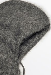 Cappuccio in lana grigio scuro, morbido e con una texture a maglia, decorato con lacci, presentato su uno sfondo bianco.