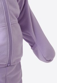 Lilla fleecejakke med glidelåslukking og elastiske mansjetter. Myk tekstur, med en avslappet passform og rundet ermedesign.