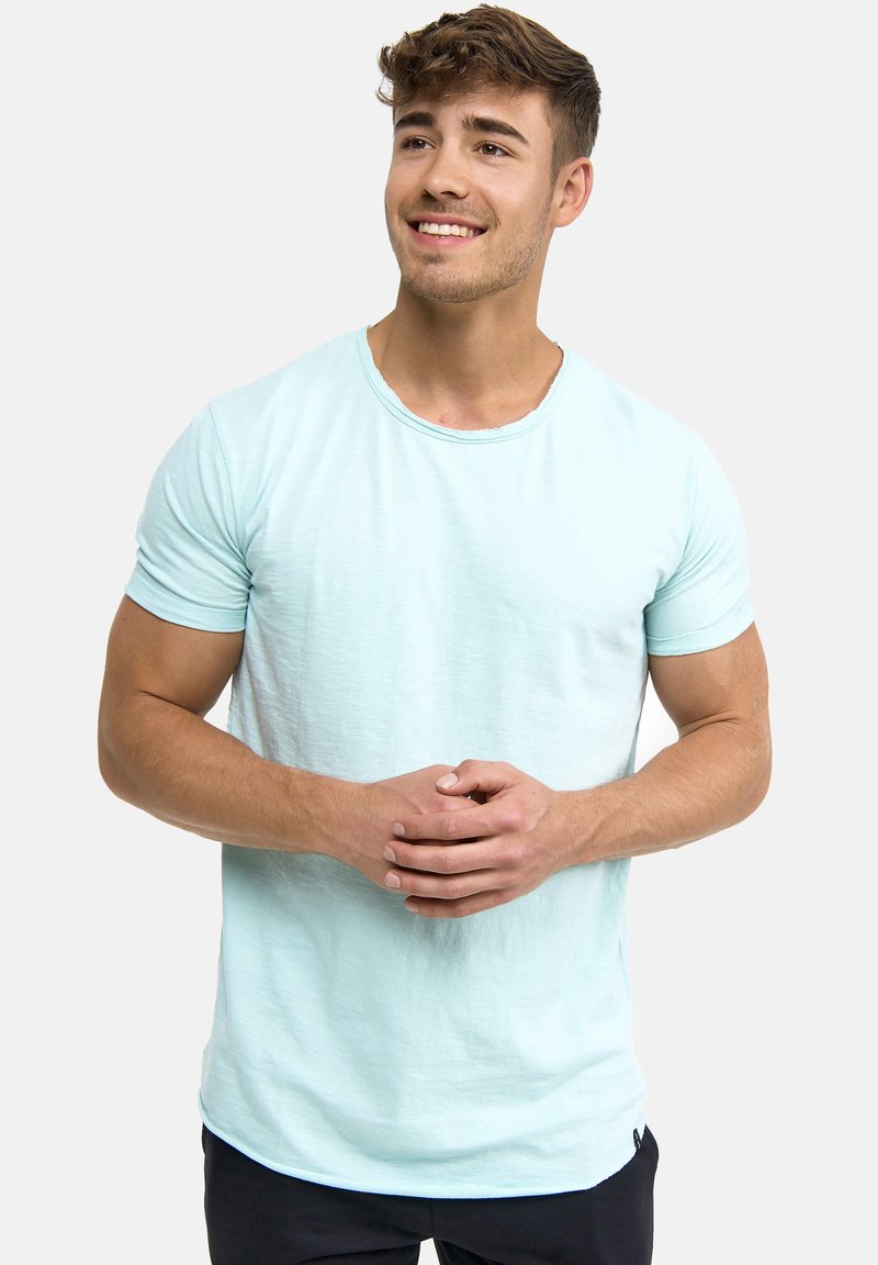 Light blue crew neck t-shirt in a textured fabric, featuring short sleeves and a curved hem. Smooth surface with no visible patterns or accents.