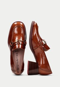 Bruna lackläder loafers med en guldspänne, fyrkantig tå och en klack med träliknande textur.