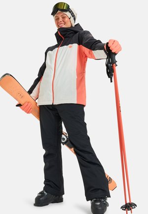 Skiklær som inkluderer en svart og korallfarget vanntett jakke med hette, svarte bukser, oransje skistaver og et snowboard.
