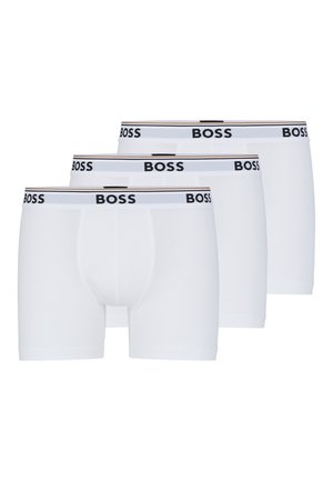 Būti trys baltos boxer kelnaitės, pagamintos iš minkštos medžiagos. Juos valdo juodos spalvos logotipas ir horizontalios juostos.