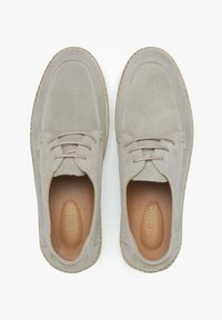 Šedé semišové šněrovací boty s texturovanou světle hnědou podešví, s tónovými tkaničkami a kulatým designem špičky.