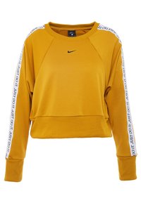 Żółta krótka bluza z raglanowymi rękawami, czarnym logo Nike oraz białymi pasami z napisem "JUST DO IT" na rękawach. Miękka tkanina.
