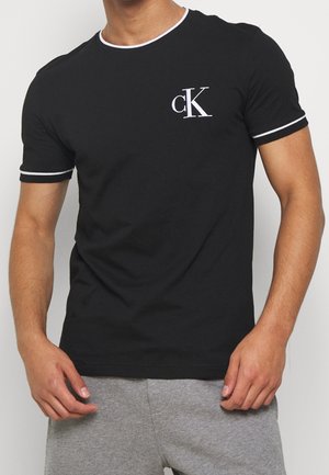 T-shirt en coton noir à manches courtes, avec des finitions blanches contrastantes sur le col et les manches, et un petit logo CK brodé sur la poitrine.