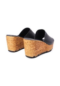 Sandali wedge neri in materiale sintetico, con una piattaforma testurizzata simile al sughero, caratterizzati da un tallone arrotondato e design aperto sulla punta.