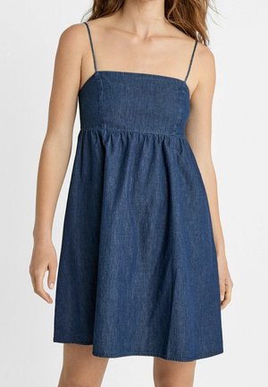 Denimmekko, jossa on neliömäinen kaula-aukko ja ohuet hihnat. Mekossa on muotoiltu yläosa, joka laskee laskostettuun A-linjaisiin helmoihin. Navy-värinen.