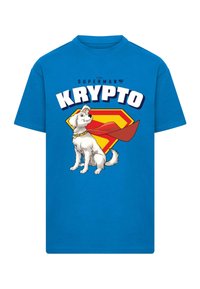 Mėlynas medvilninis marškinėliai su Krypto šuns atvaizdu, kuris turi baltus plaukus, geltoną apykaklę ir raudoną apsiaustą, išdėstytas prieš geltoną ir raudoną emblema.