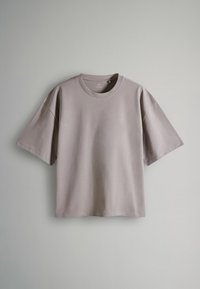 Kurzärmliges T-Shirt mit Rundhalsausschnitt aus hellem grauem Baumwollstoff. Hat einen lässigen Schnitt und eine glatte Textur. Keine sichtbaren Logos oder Muster.