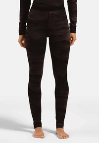 Hoch geschnittene schwarze Leggings mit strukturiertem Wellenmuster, elastischem Bund und figurbetontem Design. Das Material scheint dehnbar und weich zu sein.