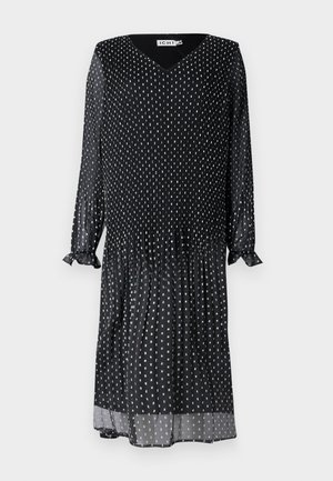 Sort kjole lavet af letvægtsstof, med V-hals, lange ærmer med flæser ved håndleddene og hvid prikmønster over det hele.