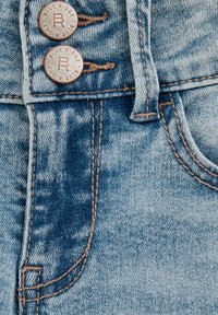 Svetlomodré denimové nohavice s mosadzne tónovanými gombíkmi s vyrazeným nápisom "Blue Ridge", kontrastným béžovým prešívaním a klasickým dizajnom s piatimi vreckami.