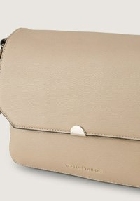 Beige Clutch aus Kunstleder mit glatter Textur, Klappenverschluss und silbernen Hardware-Details. Prägung des Markenlogos auf der Vorderseite.