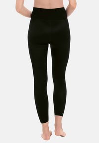 Zwarte legging met een hoge tailleband, gladde stof, getextureerde accenten en contournaden voor een aansluitende pasvorm.
