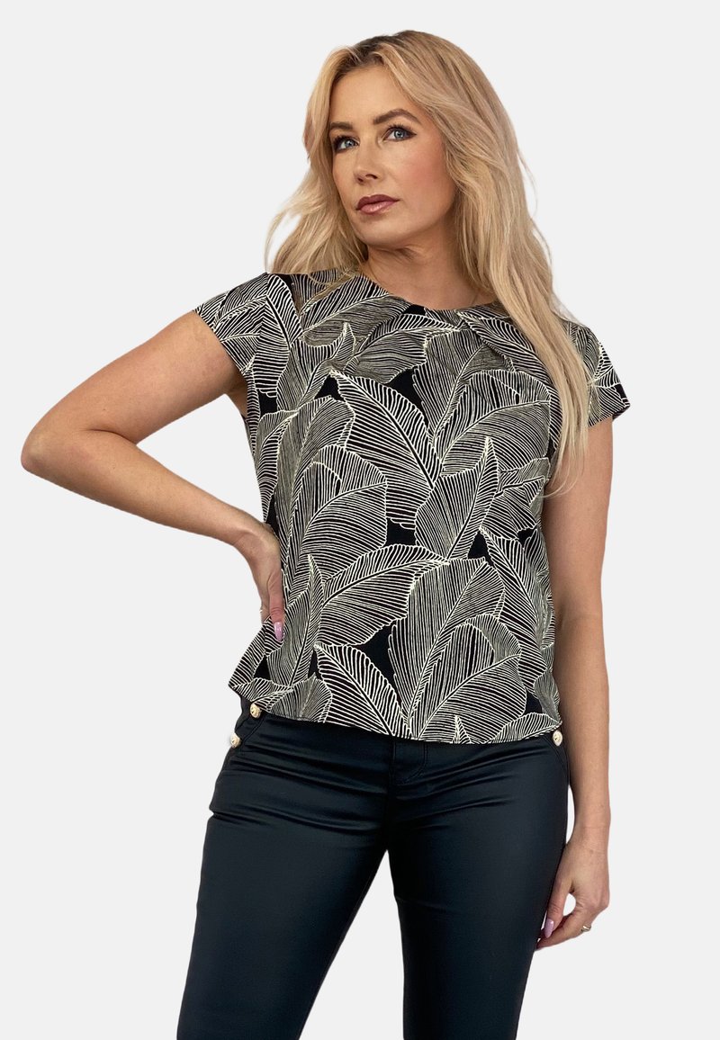 Czarna bluzka z białym wzorem liści, krótki rękaw, okrągły dekolt i luźny krój. Połączona z czarnymi spodniami z złotymi guzikami.